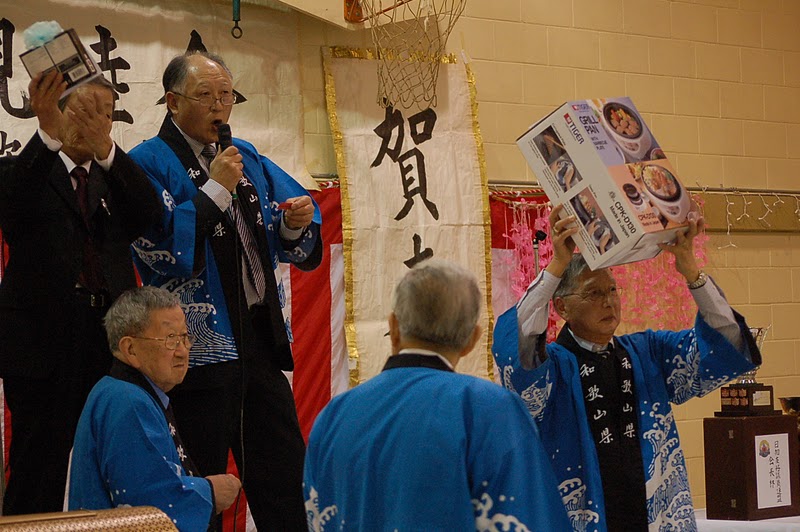 たくさんの当たりくじを読み上げるジム田中さん